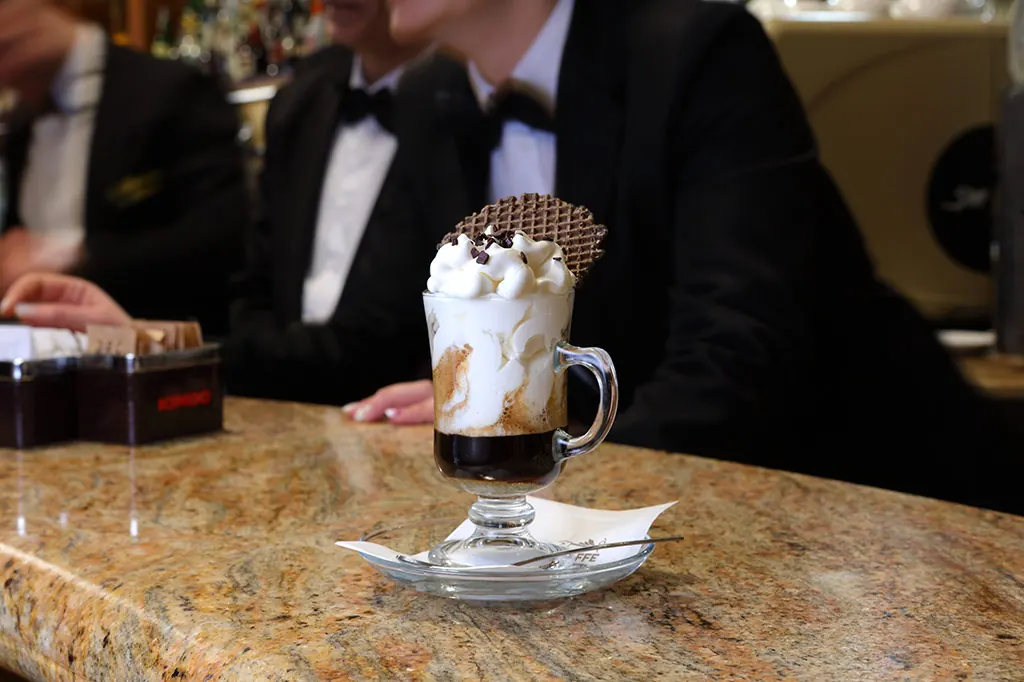 Il barman di Ceraldi Caffè serve un caffè con panna al bancone