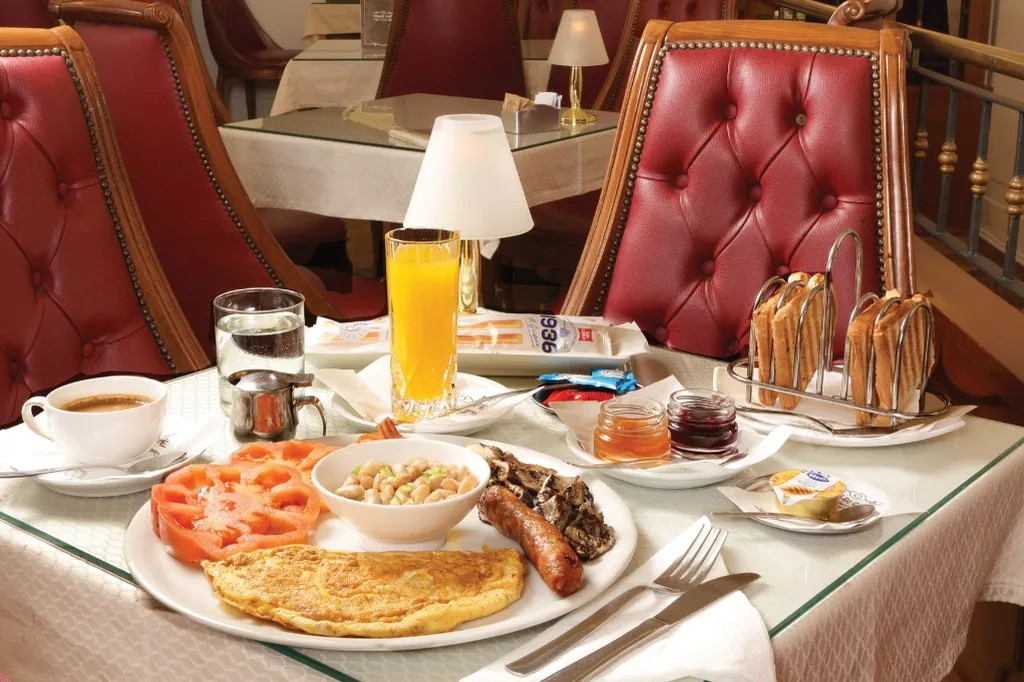 La sala di Ceraldi Caffè con le poltroncine in pelle rossa e una colazione servita al tavolo